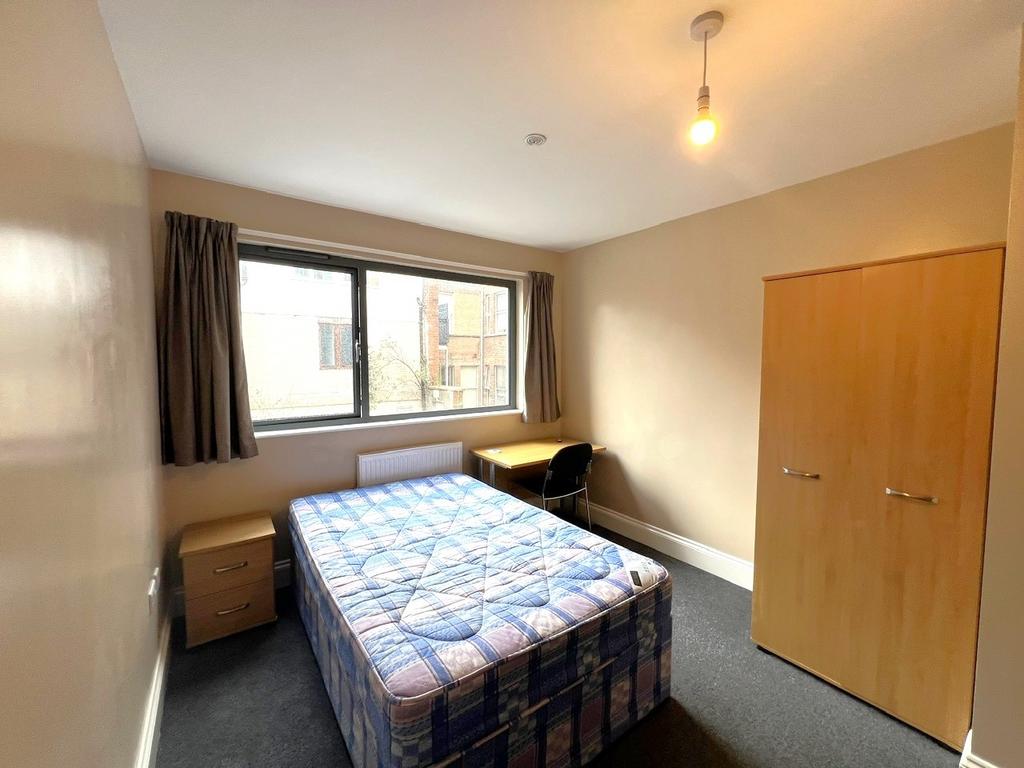 Bright double bedroom with a large window, doub...