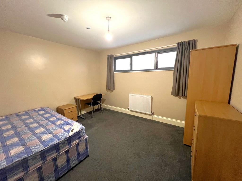 Spacious furnished bedroom with a double bed, s...