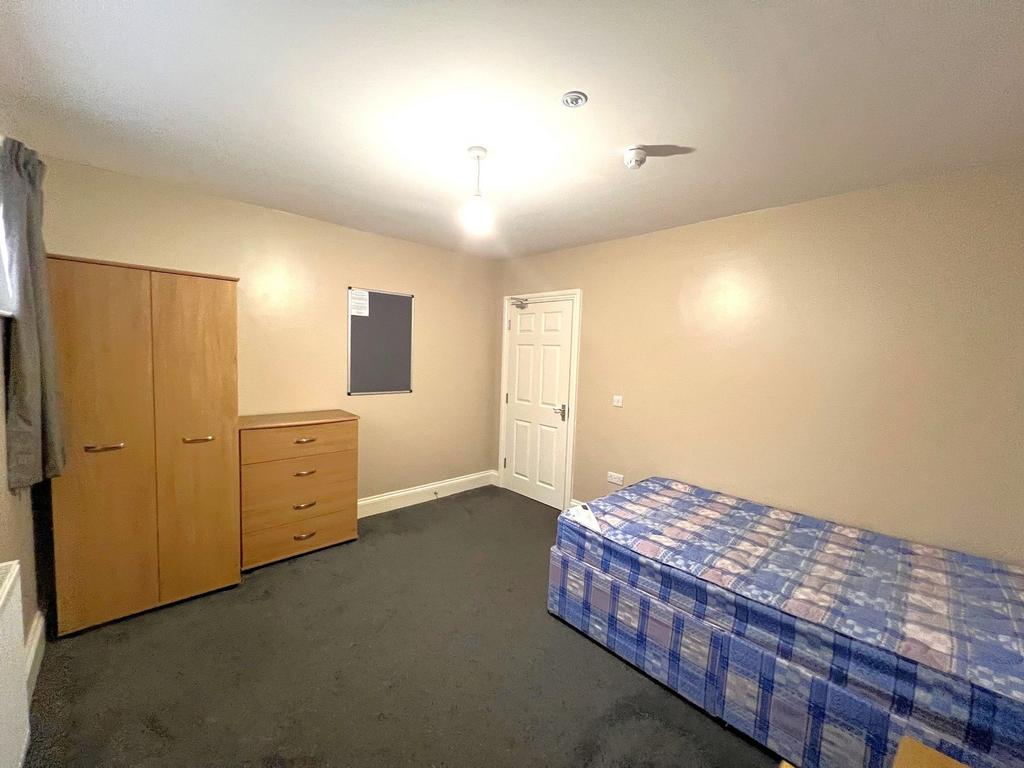 Bright, simply furnished single bedroom with a ...