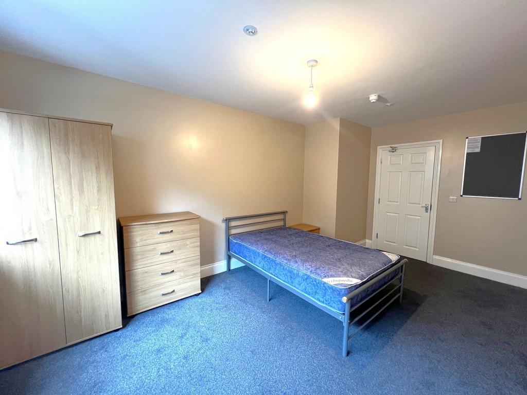 Bright, tidy single bedroom with a metal bedfra...