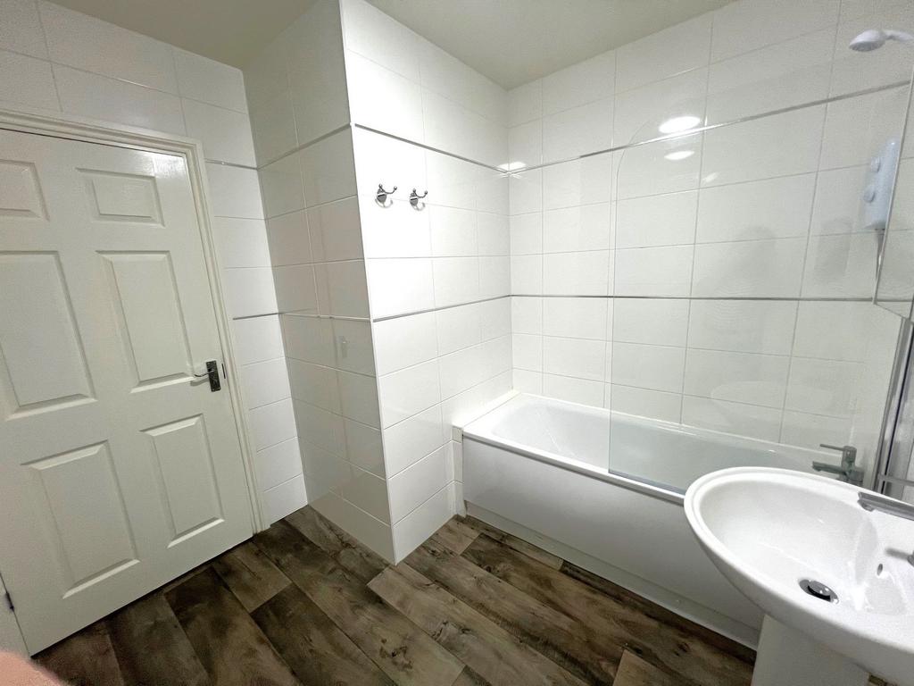 Bright modern bathroom with a tiled bath and cl...
