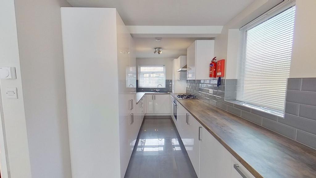 Bright modern galley kitchen with glossy white ...