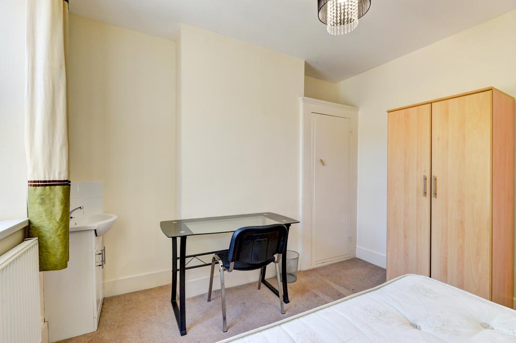 Bright, neutrally decorated bedroom with large ...