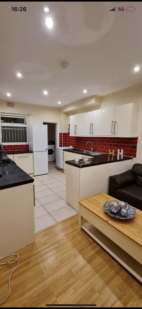 Bright open-plan kitchen area with modern white...