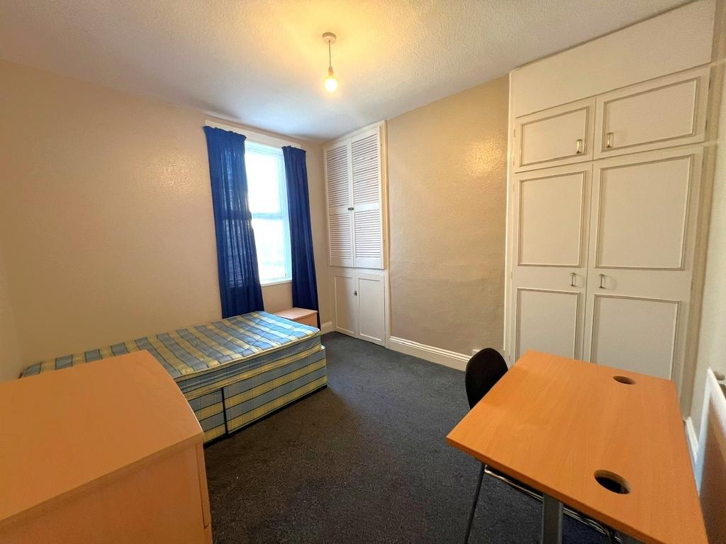 A simple single bedroom featuring a bed with a ...