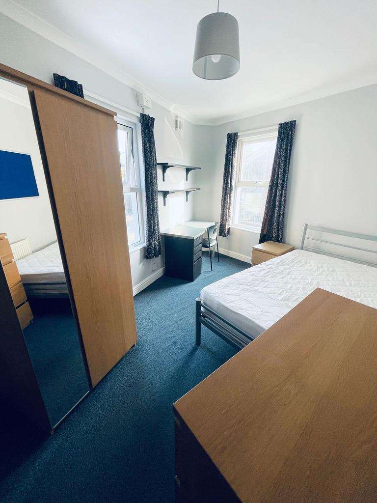 Bright, neatly furnished double bedroom with a ...