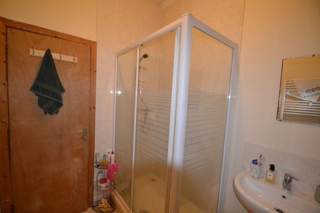 A functional bathroom featuring a shower enclos...