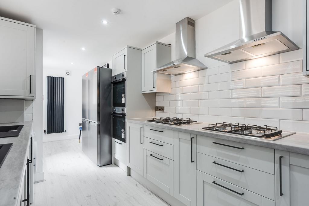 Modern, bright kitchen featuring sleek white ca...