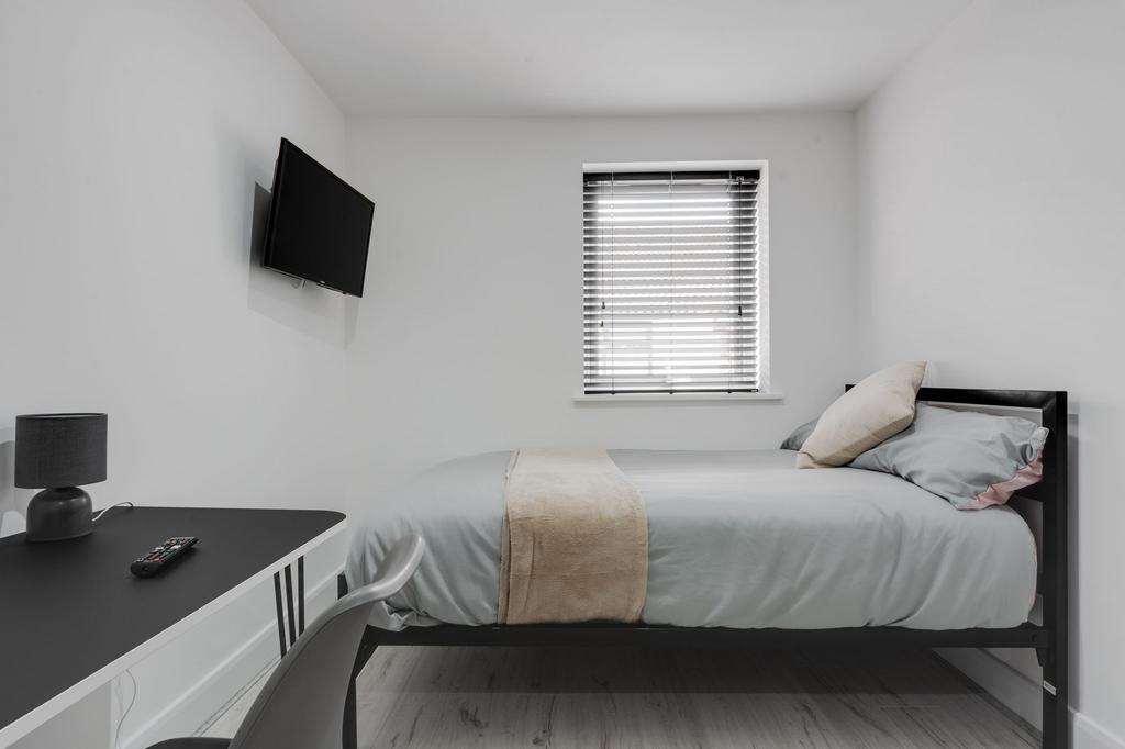 A bright and tidy double bedroom featuring a ne...