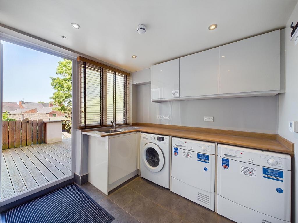 Bright utility-style kitchen with a wooden coun...
