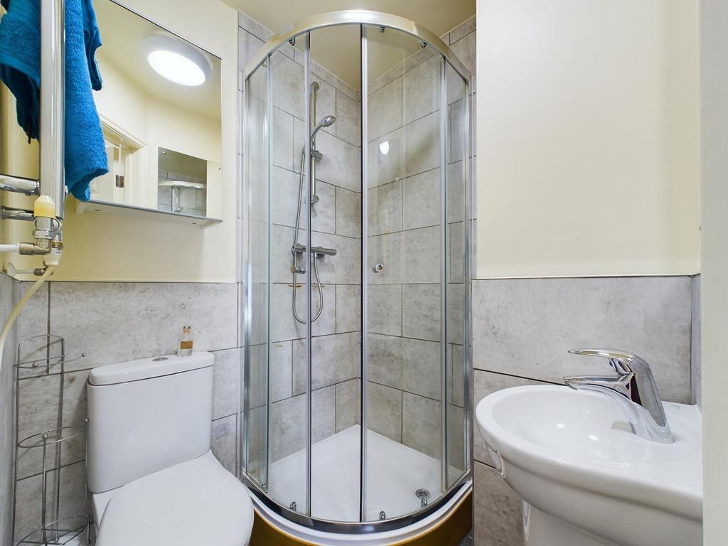 Bright, modern bathroom with a curved glass sho...