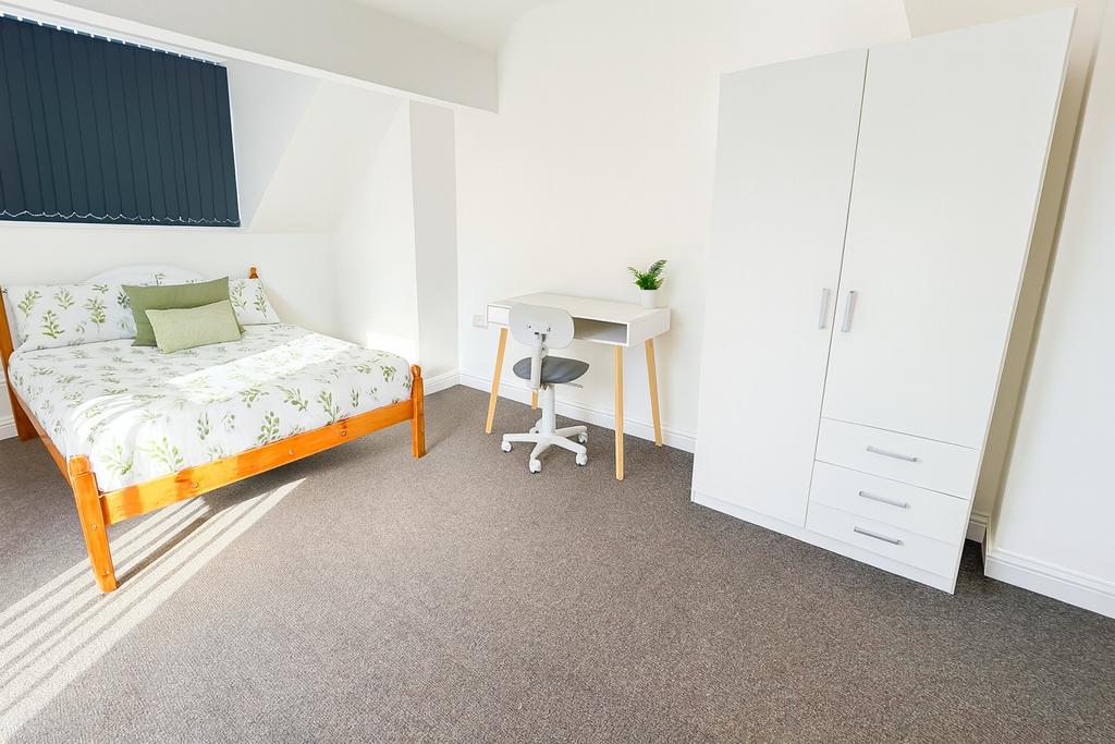 A bright and tidy bedroom featuring a comfortab...