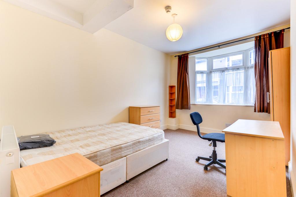 Bright, neutrally decorated bedroom with a larg...