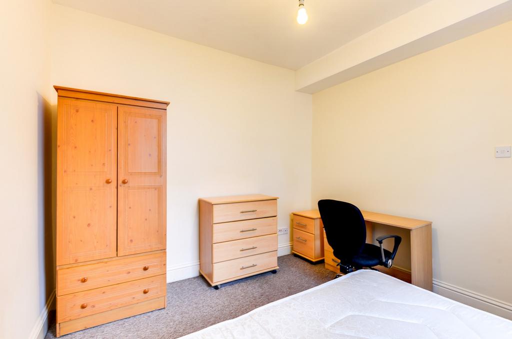 Bright, simply furnished bedroom with a double ...