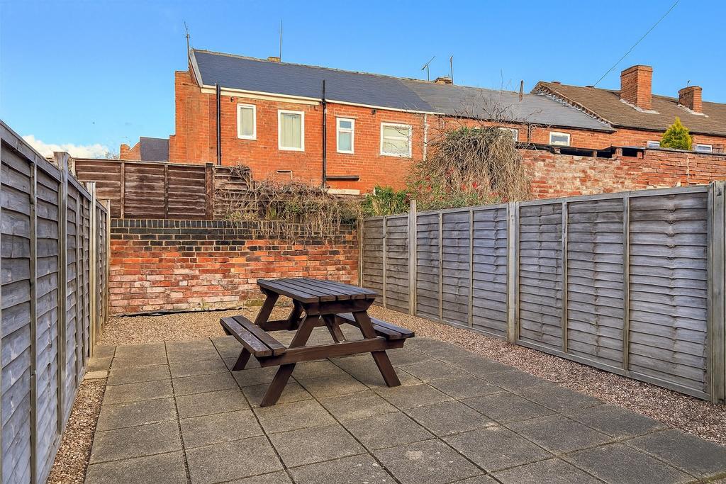 Enclosed low-maintenance rear garden with paved...