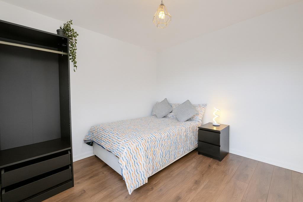 Bright, simply furnished bedroom with a double ...