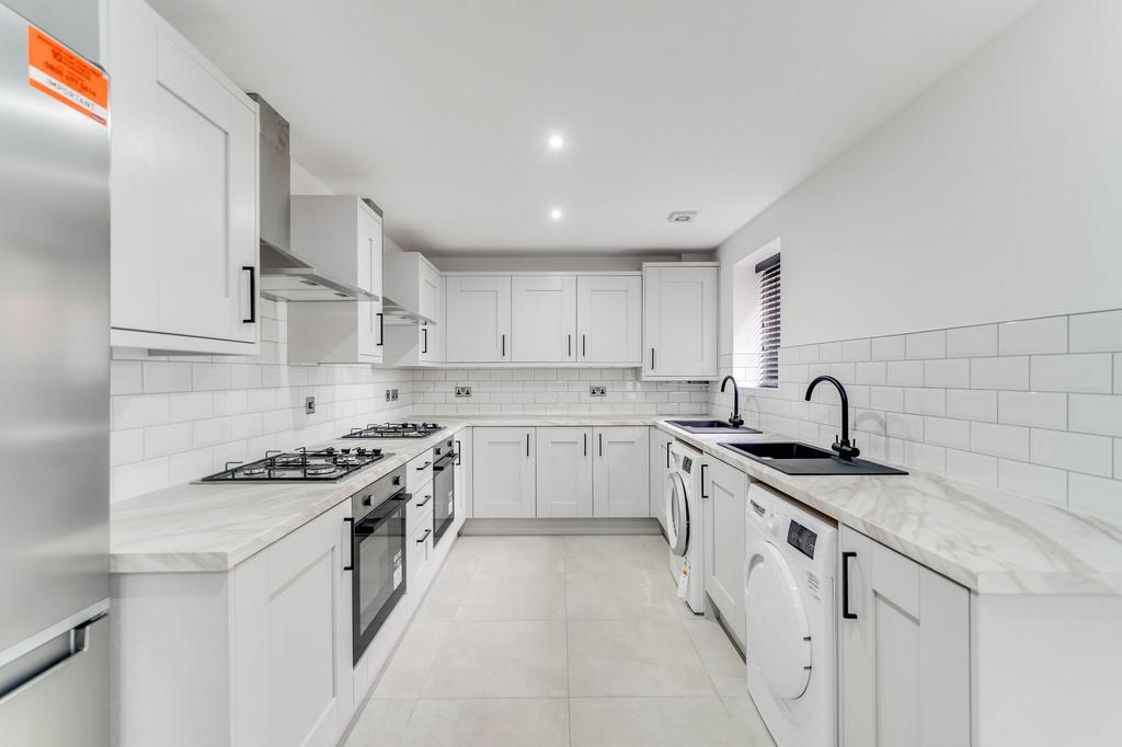 Modern kitchen with sleek white cabinets, marbl...