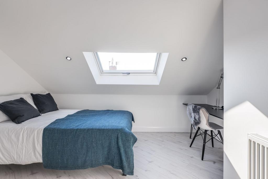 Bright and modern single bedroom featuring a co...