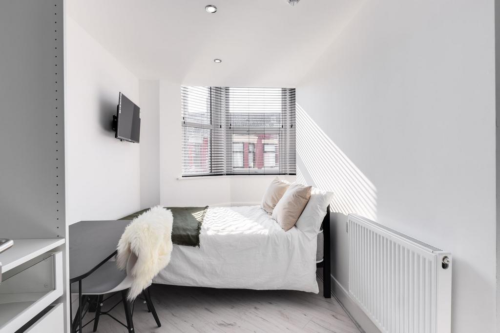 Bright and modern single bedroom featuring larg...