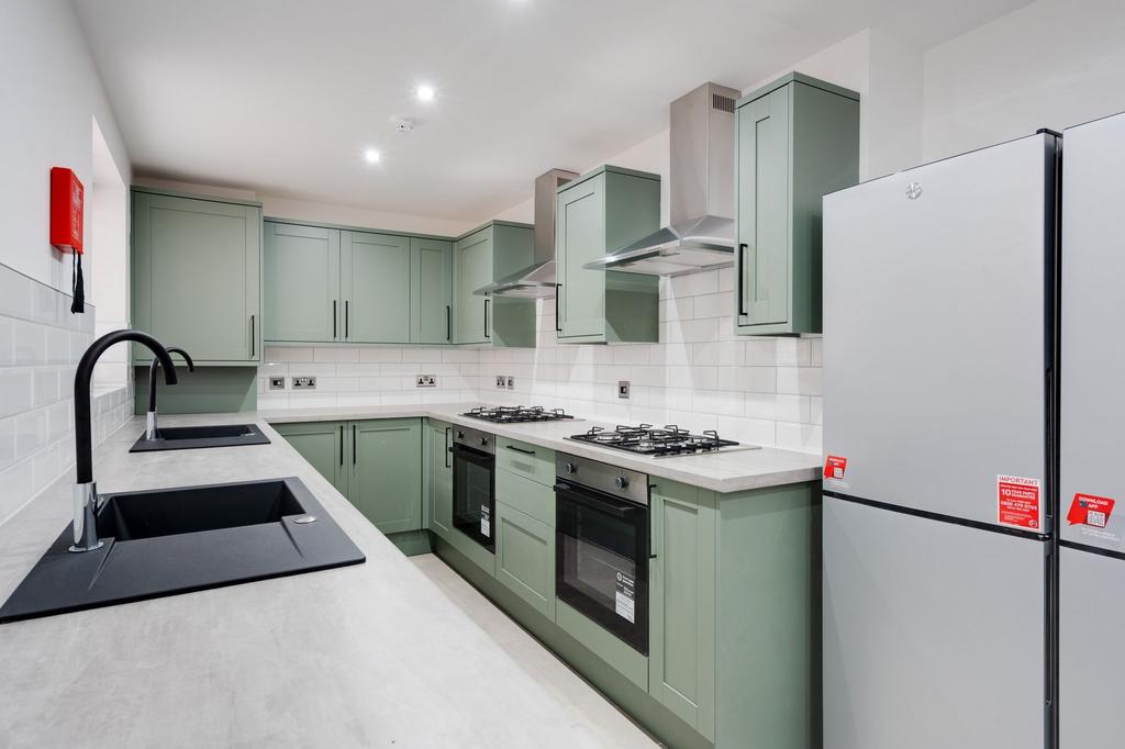 Modern galley-style kitchen with muted green fi...