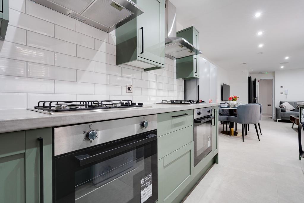 Modern open-plan kitchen with stylish sage-gree...