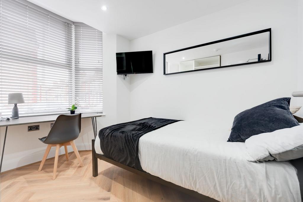 Modern bedroom featuring a comfortable bed with...