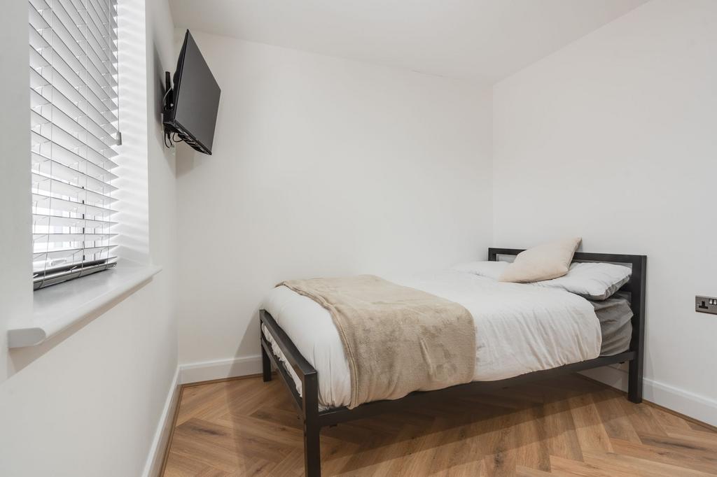A cozy double bedroom featuring a simple black ...