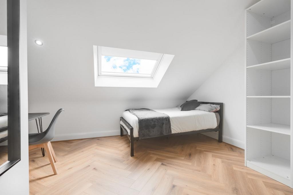 A bright, modern bedroom featuring a single bed...