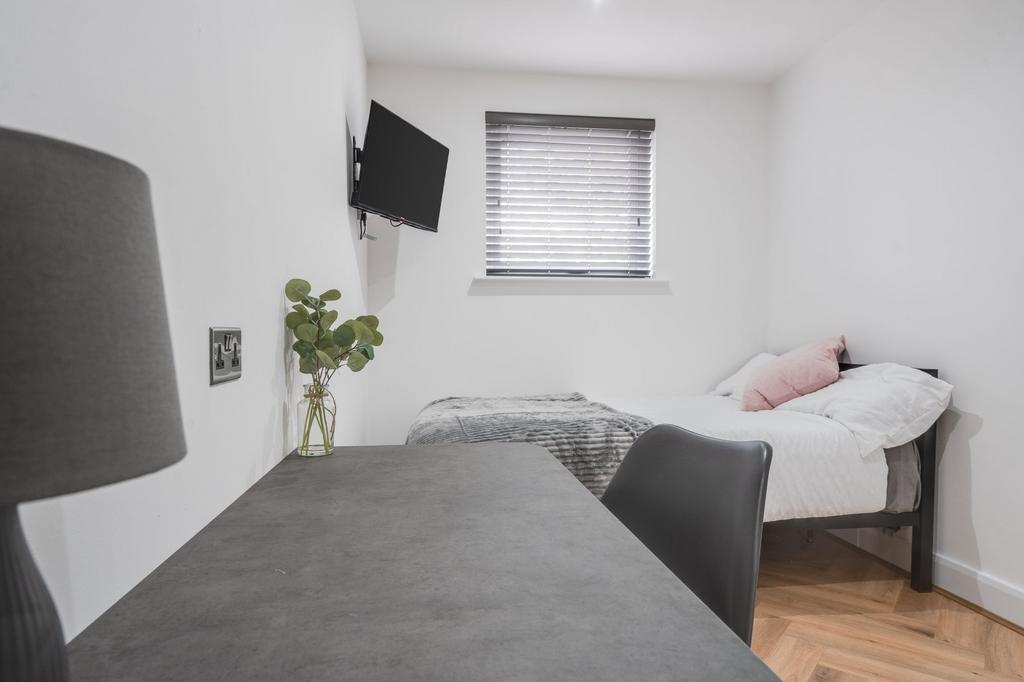 A bright and well-maintained bedroom with a com...