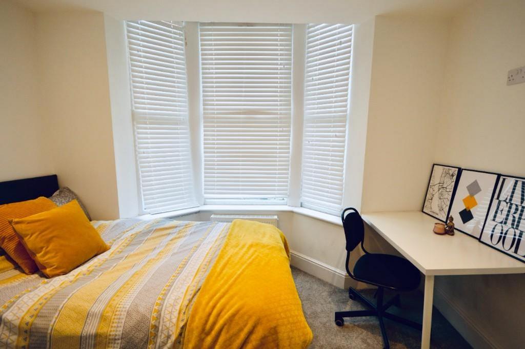 Cozy double bedroom featuring a bright bay wind...