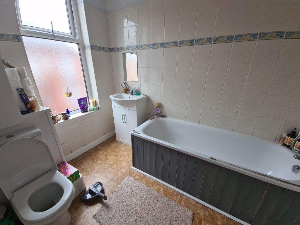 Bright, tiled bathroom with a full bath, basin ...