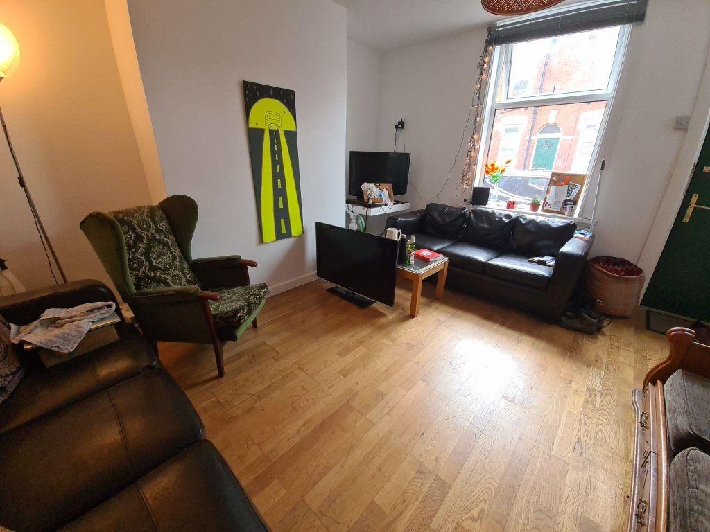 Bright lounge with large front window, hardwood...