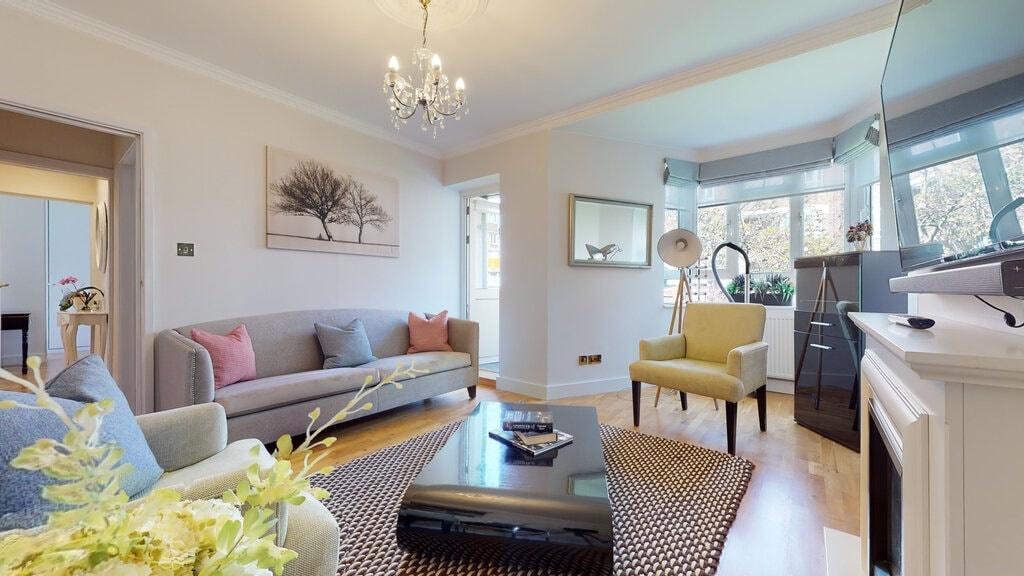 Bright, stylish living room with a large bay wi...