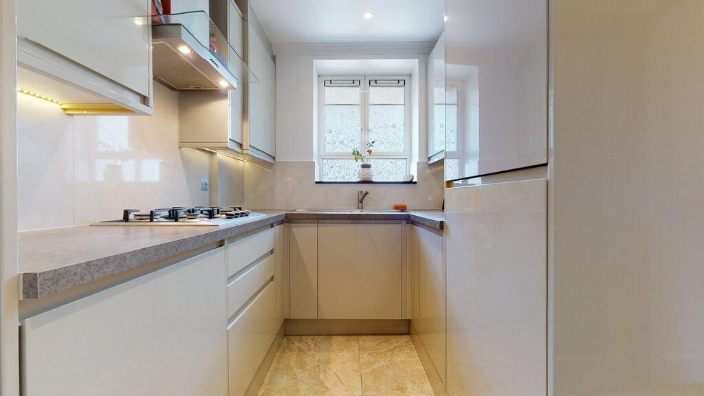 Bright, modern galley kitchen with sleek cabine...