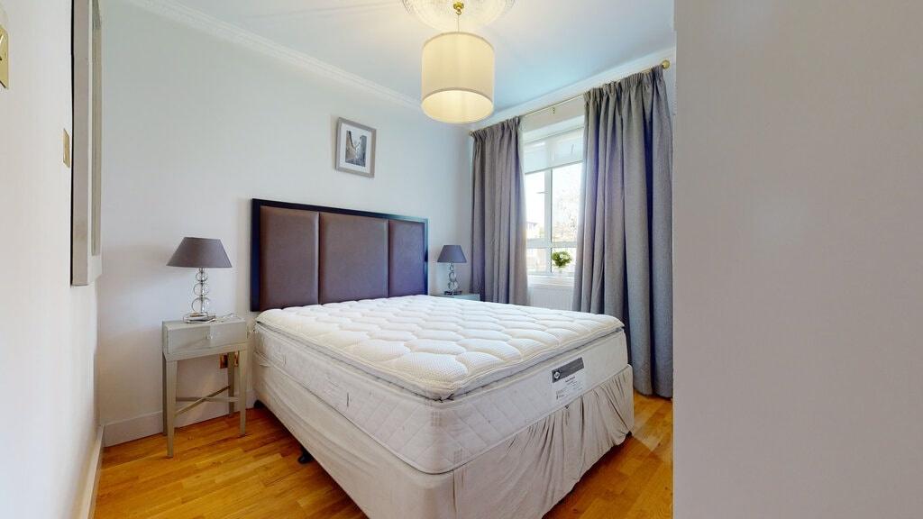 Bright, neatly styled double bedroom with a com...