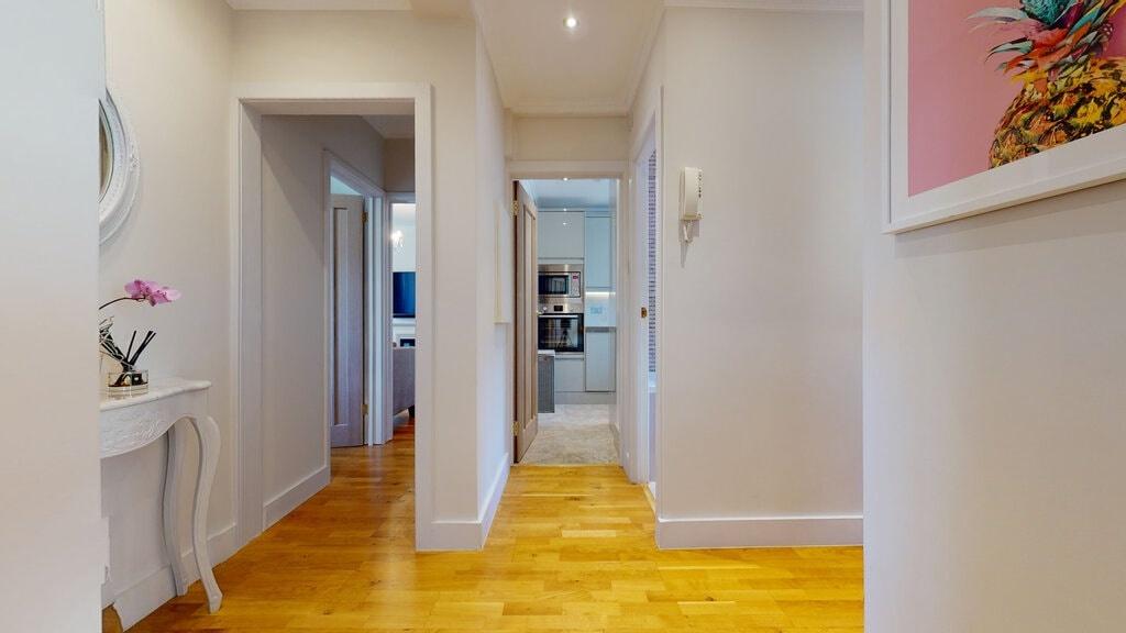 Bright, modern hallway with warm wooden floorin...