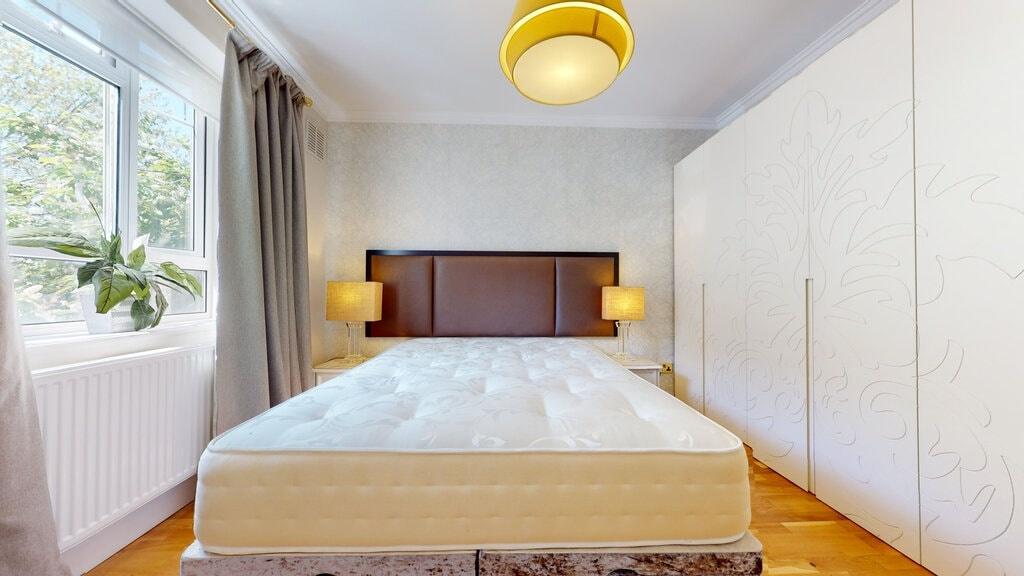 Bright, neatly styled bedroom with a comfortabl...