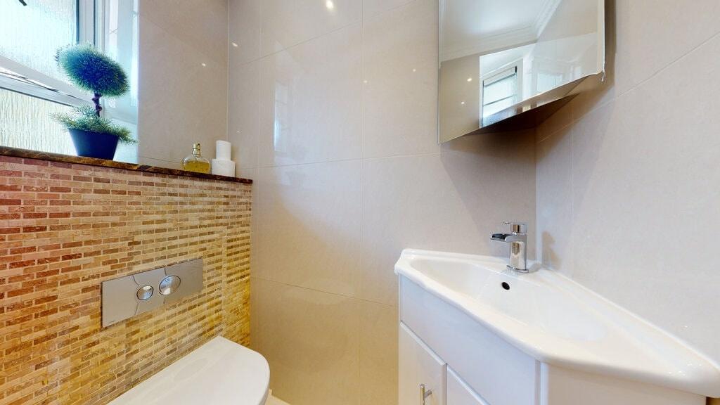 Bright, modern WC with a sleek corner basin, co...