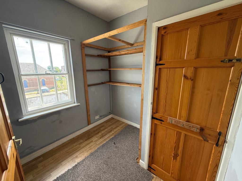 Bedroom 3 with storage cupboard and window to rear
