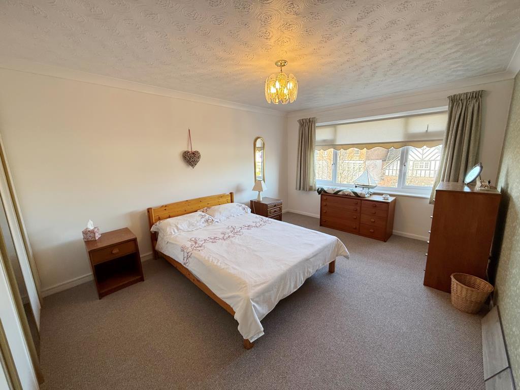Carpeted main bedroom with window