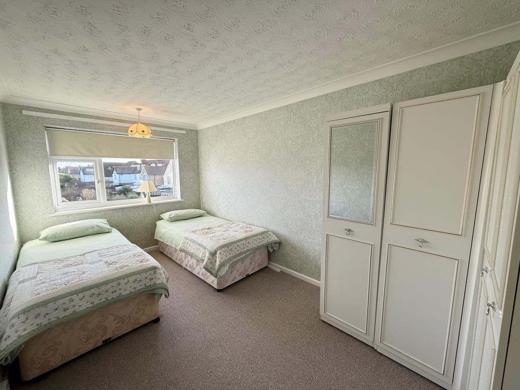 Carpeted 2nd bedroom with green wallpaper