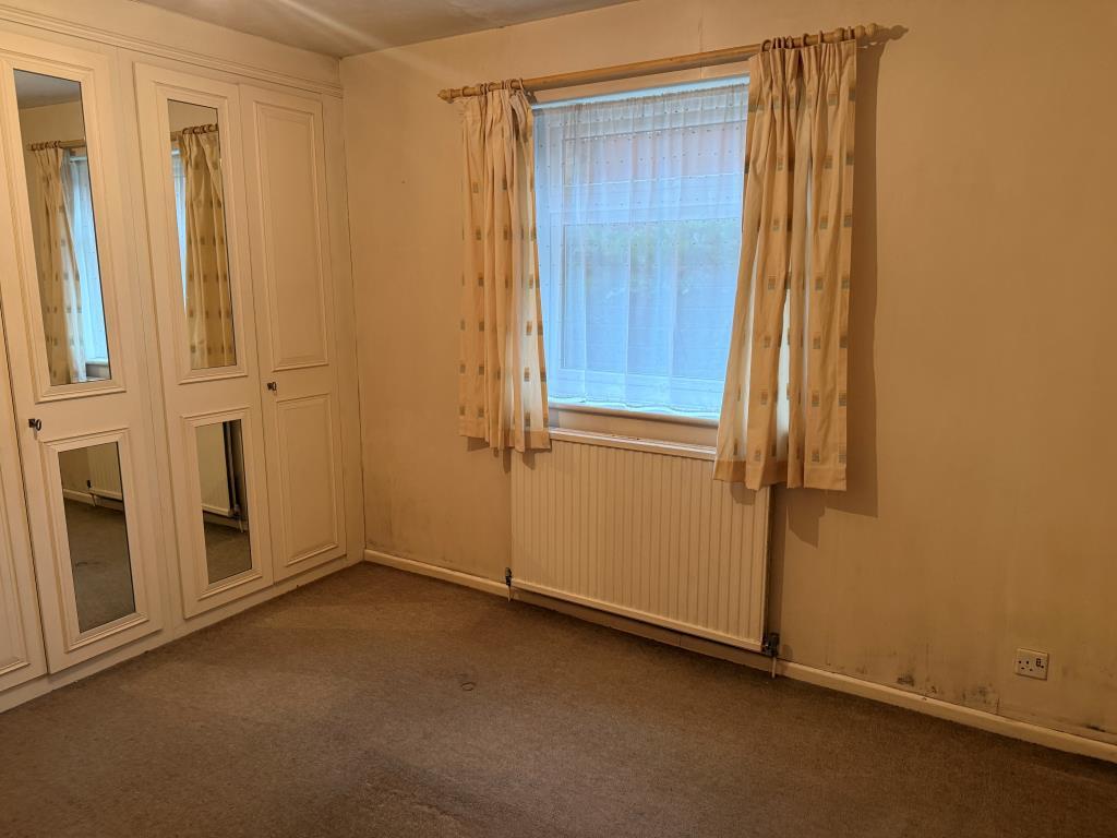 Rear double bedroom with window and wardrobe
