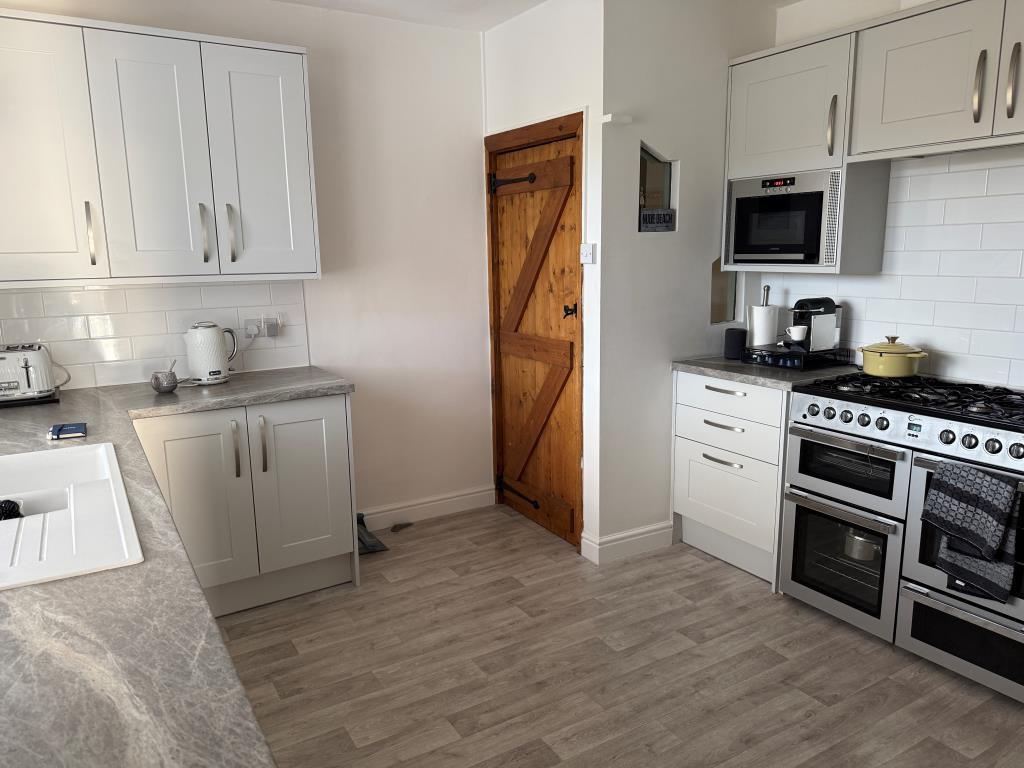 Fitted kitchen units with door to further bedrooms