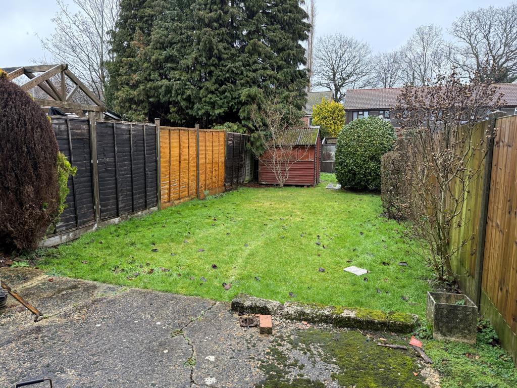Rear garden with patio area and lawn with sheds