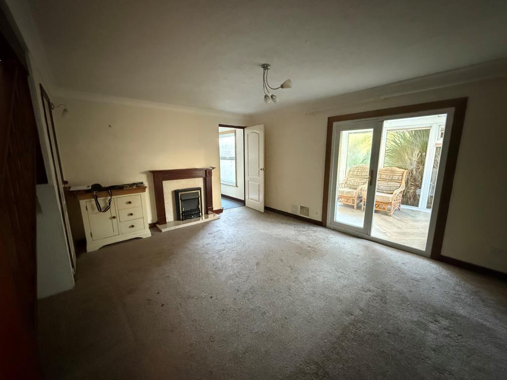 Carpeted lounge with doors to conservatory and din