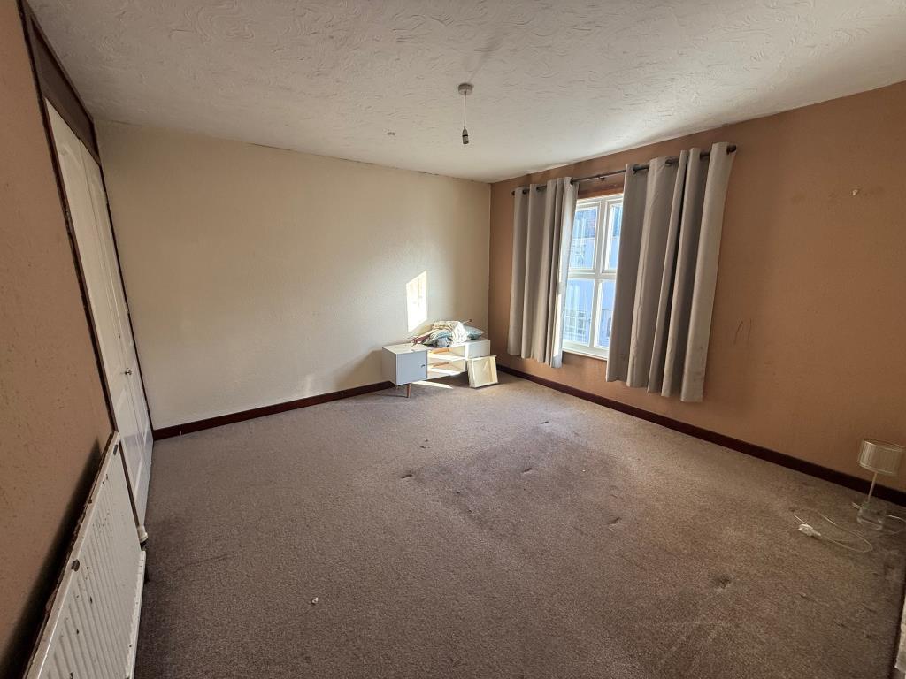 Carpeted bedroom one with window and built in ward