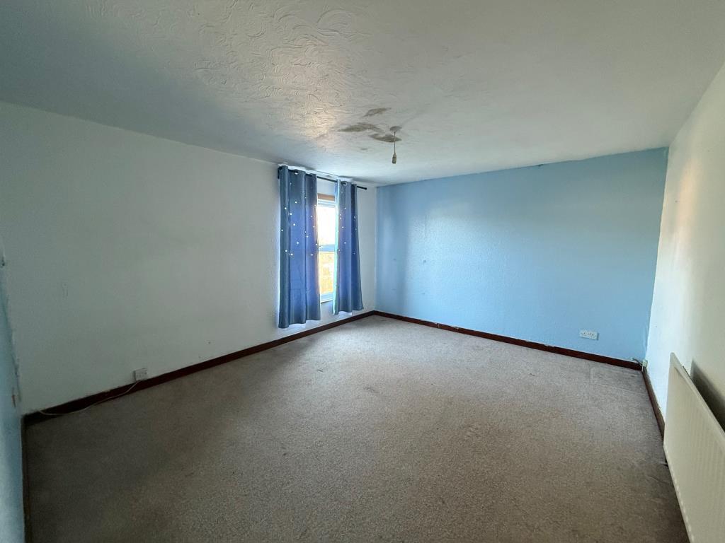 Carpeted 2nd bedroom with window and radiator