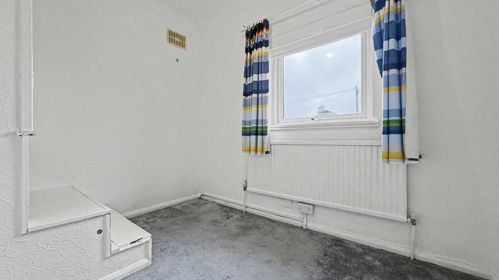Bright single bedroom with a large window, fitt...