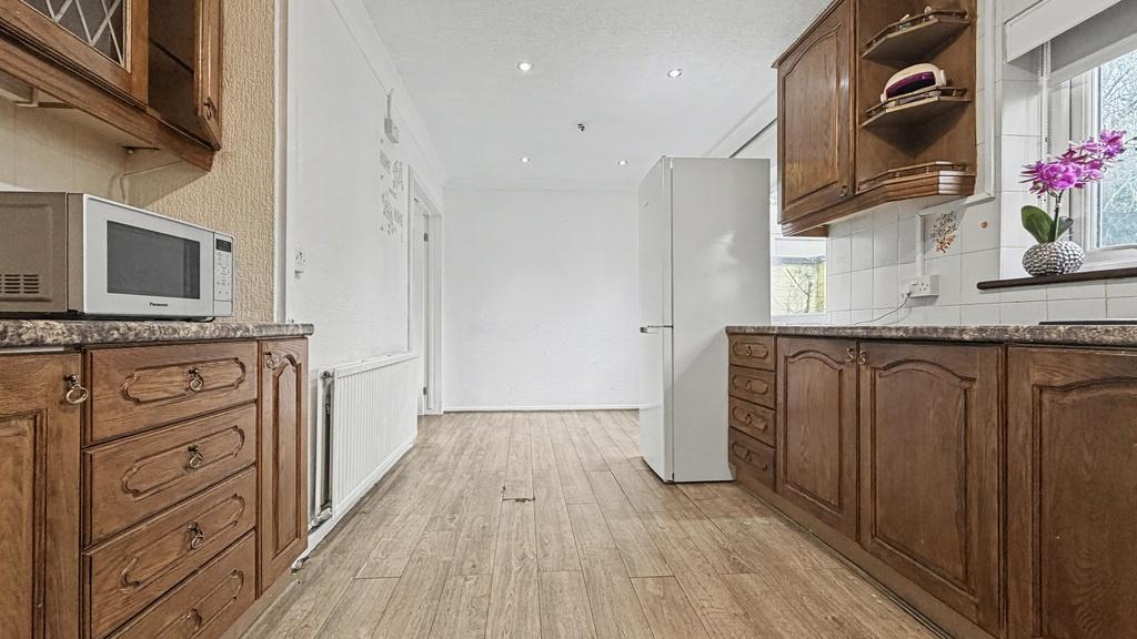 Bright galley-style kitchen with warm wooden ca...