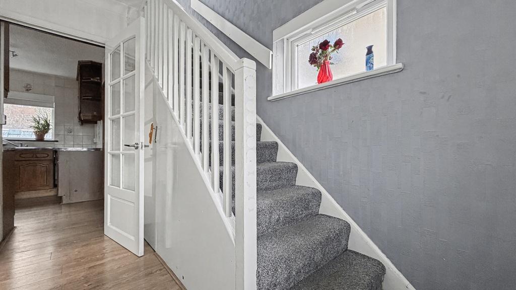 Bright, modern entrance with carpeted stairs, n...